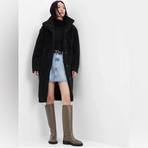 Cozy sherpa coat. Funnel neck. Long sleeves. Button front. Front slant pockets.